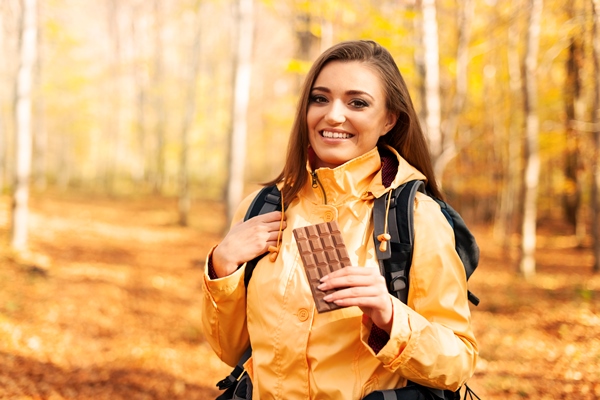 smiling female hiker with dark chocolate - Кофе "Походный"