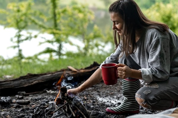 young woman resting near the fire with a cup of warming drink in the forest near the river 169016 11791 - Компот из яблок и апельсинов по-походному
