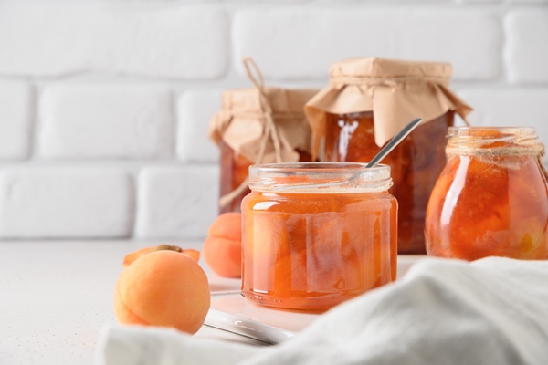 apricot jam in glass jar with fruits summer harvest and canned food - Абрикосовое варенье