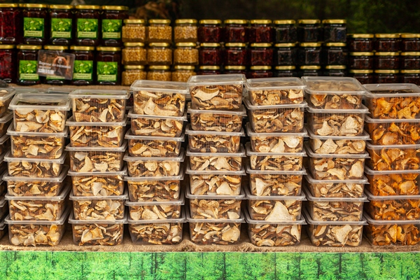 dried mushrooms in plastic containers at a christmas rural fair chanterelles and porcini mushrooms forestry - Сбор, заготовка и переработка дикорастущих плодов, ягод и грибов