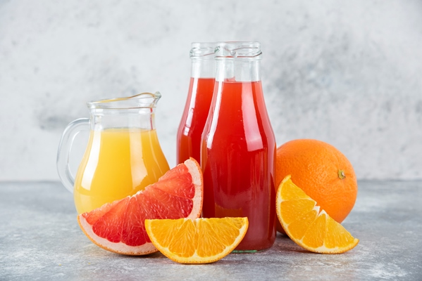 glass pitchers of grapefruit juice with slices of orange fruits - Леденцы на палочке