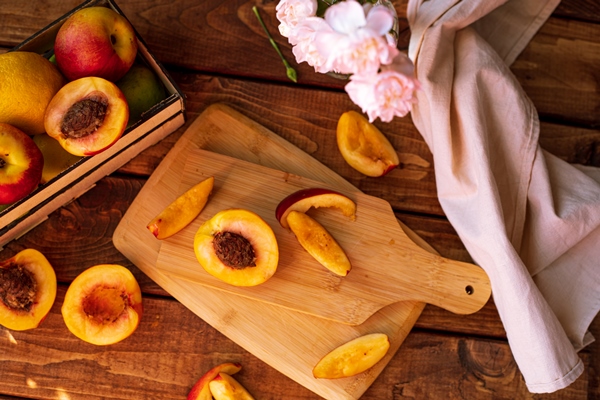 sliced nectarines on a chopping board on a wooden table halves and slices of sweet peach - Варенье из персиков