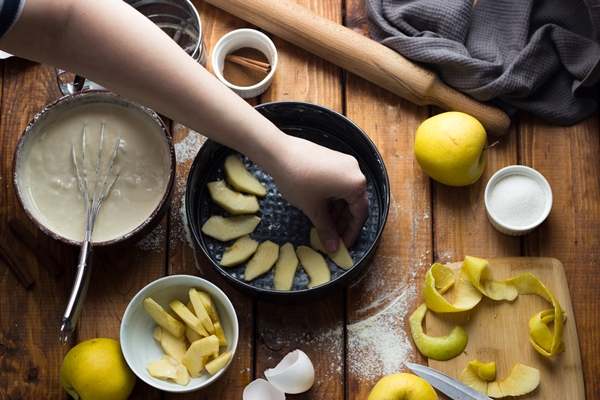 a woman cooks an apple pie on a wooden table the process of making a pie 1 - Шарлотка с яблоками классическая