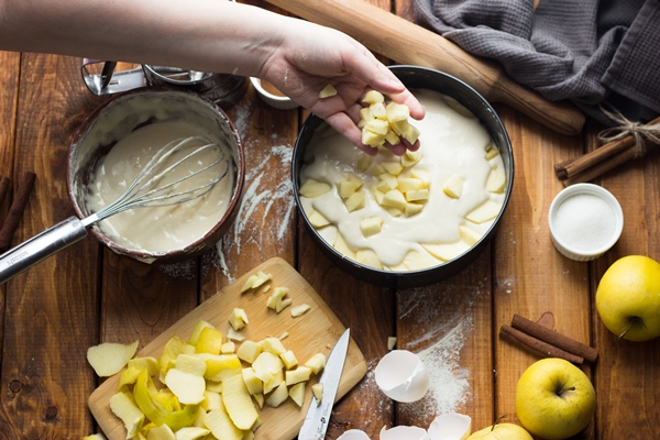 a woman cooks an apple pie on a wooden table the process of making a pie 3 - Шарлотка с яблоками классическая