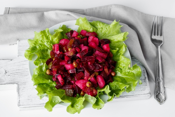 russian salad vinaigrette on a gray background traditional vegetable dish with red beets on a plate - Мочёная брусника