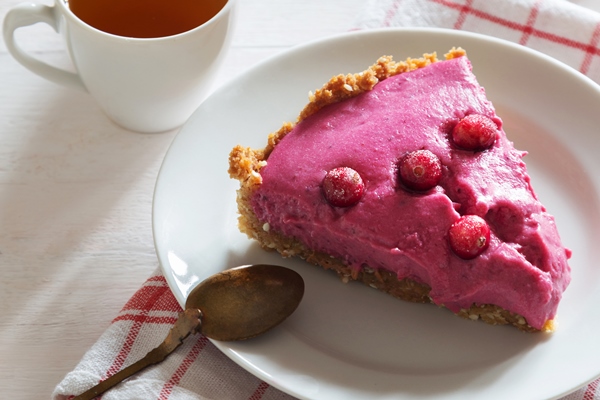 vertical photo of cranberry tart with berries spoon and tea - Мочёная брусника