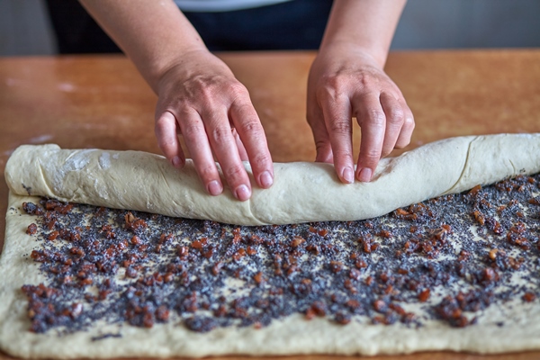 woman rolls dough with jam for baking 1 - Постный маковый рулет с мёдом и изюмом