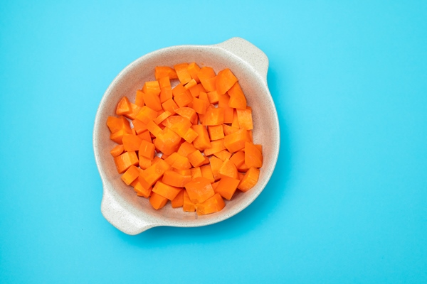cut cubes of fresh carrot in the bowl on blue - Лагман из свинины в мультиварке