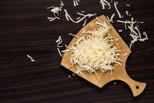 grated cheese on a cutting board - Пицца из кабачков