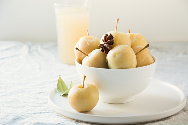 pickled apples in bowl and apple sidr on white stone table - Мочёные яблоки в холодном рассоле