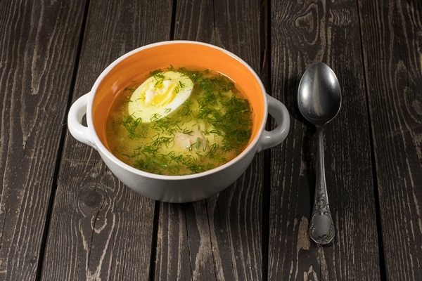 soup with noodles chicken egg and dill on a dark wooden background in a plate with a spoon - Старинные секреты приготовления мясных бульонов