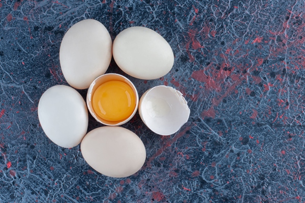 top view of fresh white chicken egg broken with yolk and egg white - Драчена миндальная с ванилью