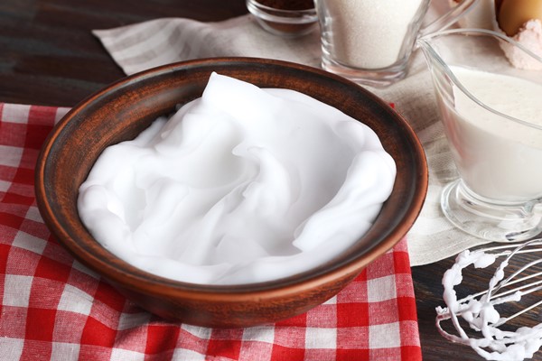 whipped egg whites and other ingredients for cream on wooden table closeup - Драчена миндальная с ванилью