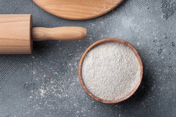 rye flour in a wooden bowl top view on a grey concrete background - Бородинский хлеб