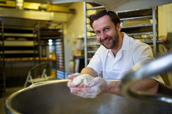 smiling baker preparing dough - Карельский хлеб