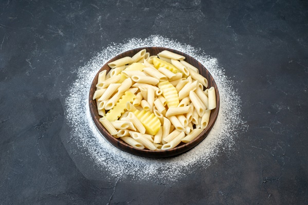 top view tasty penne pasta with potato in bowl sprinkled flour on table copy place - Разварной картофель с жареным луком и макаронами