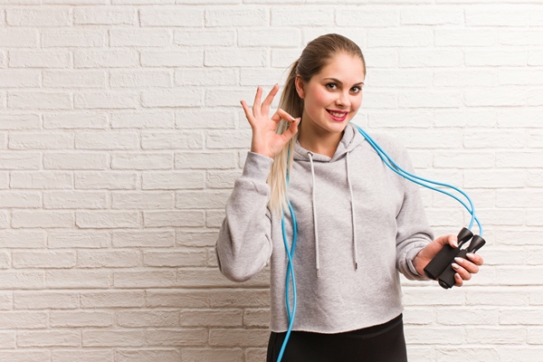 young fitness russian woman holding a jump rope against a bricks wall - Углеводная питательность рациона