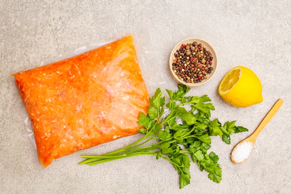 raw minced red fish stuffing on a stone surface ingredient for making fish balls casseroles terrine pate spices salt parsley lemon on a stone surface top view - Пельмени