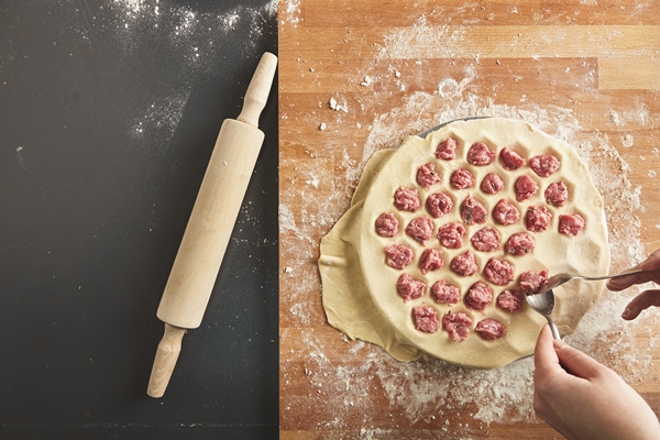 top view filling dumplings mold with minced meat all isolated on old vintage table and wooden board rolling pin near step by step guide cooking ravioli or pelmeny - Пельмени