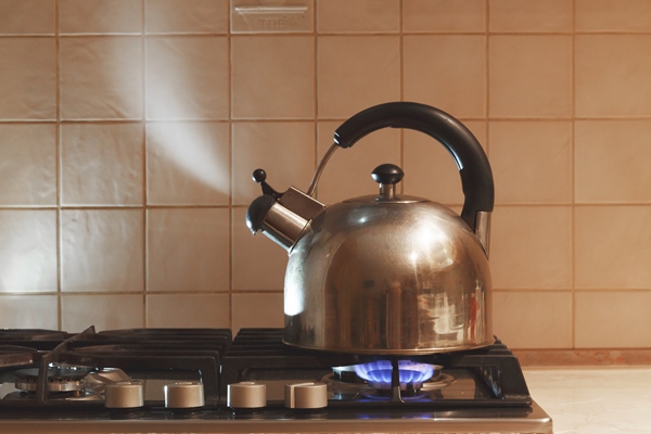 water boils in a metal teapot on a gas stove - Блинцы тонкие заварные на кефире и яйцах