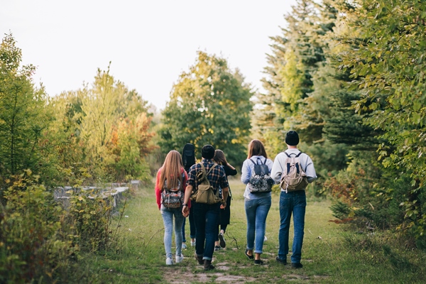 group of friends with packpacks in the forest - Лещина: сроки сбора лесного ореха и рецепт приготовления