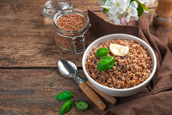 buckwheat porridge with butter and basil on a brown wall side view copy space - Каша гречневая рассыпчатая (школьное питание)