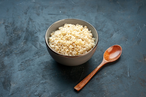 front view cooked pearl barley inside plate on dark surface - Суп крестьянский с перловой крупой (школьное питание)