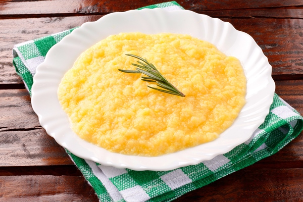 polenta in white dish on rustic wooden table cream of corn or mamaliga - Пшённая каша молочная вязкая (школьное питание)