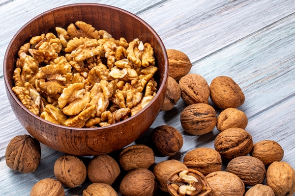 side view of a bowl with walnuts on rustic - Постный грузинский соус для салатов