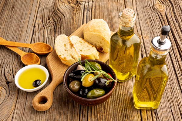 high angle olives mix bread and oil bottles - Закуска с маслинами