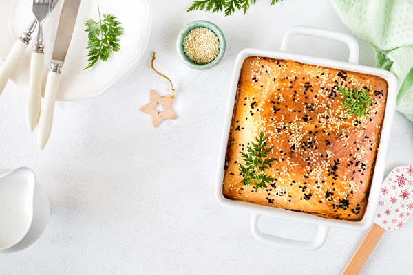 homemade closed pie with vegetables on a white concrete background ingredients for a cabbage and carrot pie on the table - Святочные кулинарные традиции: ржаной пирог с рыбой