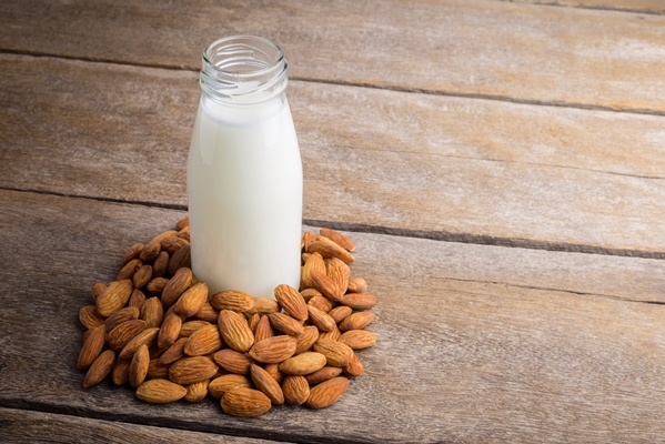 almond milk in bottle with almonds - title=