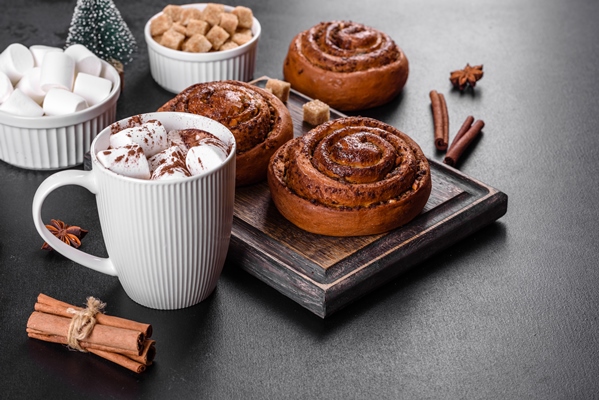 freshly baked cinnamon roll with spices and cocoa filling on a black background cinnabon buns swedish breakfast - Напиток молочный из кэроба