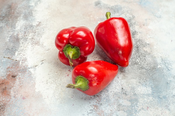 front view red bell peppers nude background free space - Салат с кальмарами, огурцами и яйцами