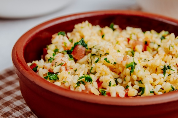 side view bulgur with tomatoes wooden bowl - Кускус с помидорами и сладким перцем