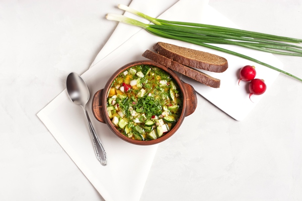 cold okroshka with fresh vegetables meat clay cup stands gray - Окрошка на березовом соке, постный стол