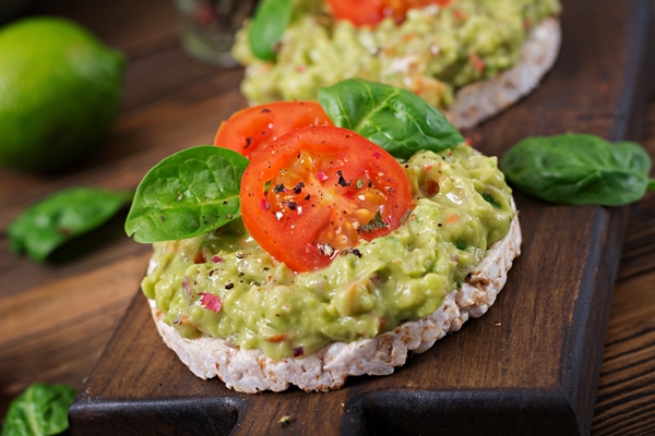 healthy breakfast sandwich crisp bread with guacamole tomatoes wooden table - Блюда из икры на Лазареву субботу