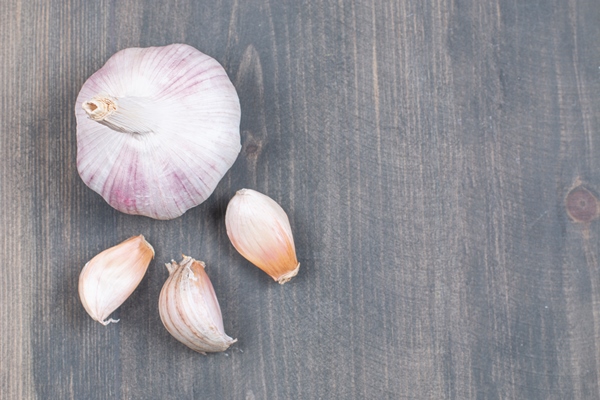 whole garlic cloves wooden surface - Овощная икра из шпината