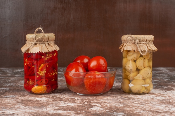 pickled red peppers mushrooms glass jar marble table with bowl pickled tomatoes - Помидоры солёные