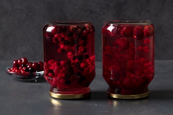 homemade canned compote with cherries currants two jars dark gray background - Компот из вишни и красной смородины на зиму