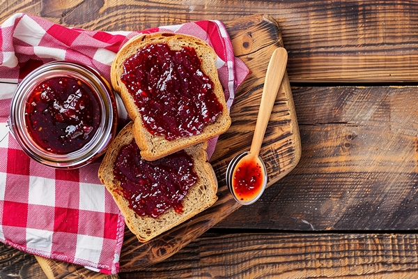 loaf bread with jam jam wooden table - Варенье из брусники