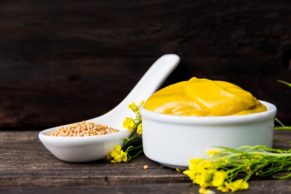 mustard sauce with its ingredients turmeric seeds flowers - Дижонская горчица