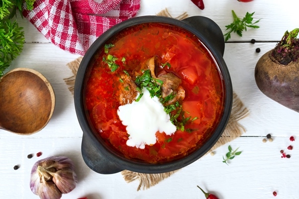 traditional ukrainian borsch with young vegetables meat black clay pot white wooden surface - Борщ московский