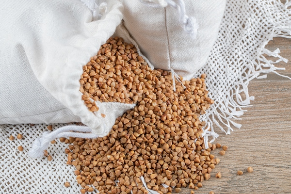 bunch raw buckwheat out white sack with spoon - Как хранить крупы