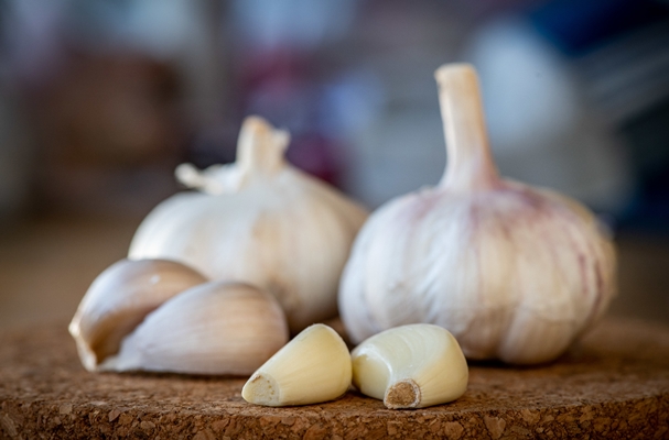 closeup garlic bulb cloves round cork board - Чесночный аромат без неприятного запаха