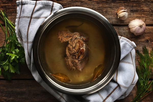 meat broth from beef metal pan wooden table - Крепкий говяжий бульон бифти