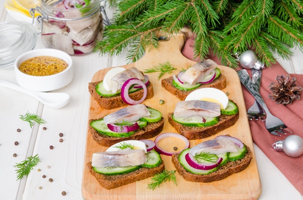 open sandwich with rye bread fresh cucumber pickled onions herring dill appetizer new year christmas - Открытый бутерброд с ржаным хлебом, свежим огурцом, маринованным луком, сельдью и укропом