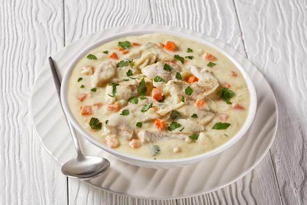poached fish milk base sauce with vegetables spices herbs white bowl wooden table english cuisine - Рыба-пашот в молоке с овощами