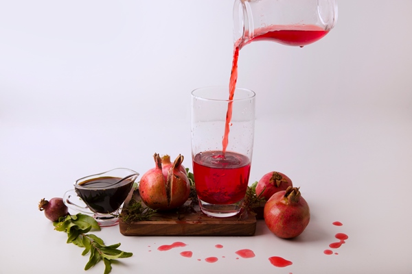 pomegranates with red sauce juice wooden board - Наршараб