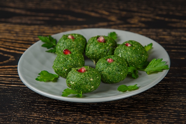 spinach pkhali decorated with parsley pomegranate georgian appetizer gray plate dark wooden table - Пхали из стручковой фасоли